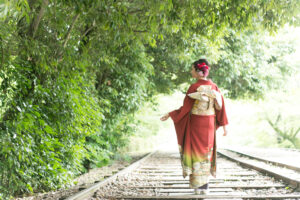 線路の上を歩く振袖姿の女性