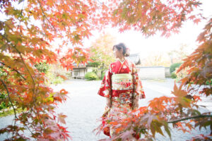 京都の紅葉に囲まれた振袖姿の女性