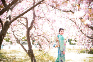 振袖姿で桜の木のに立つ女性