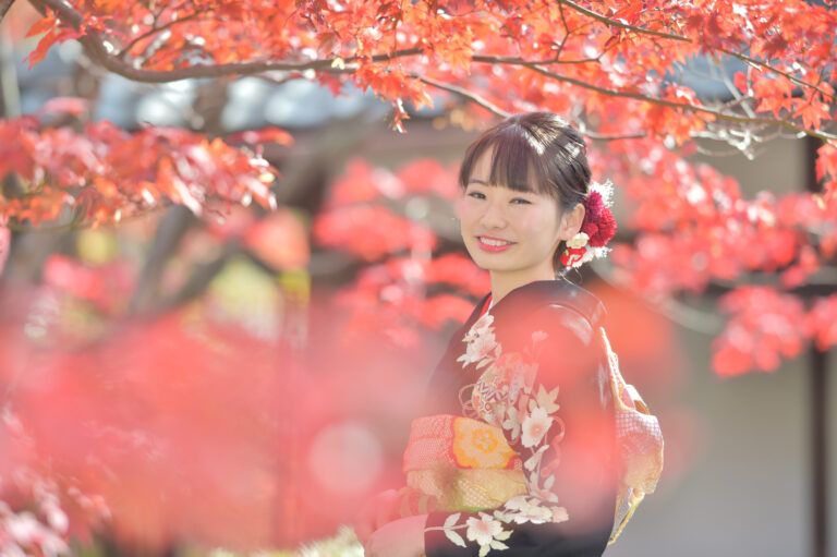 紅葉に囲まれた振袖姿の女性